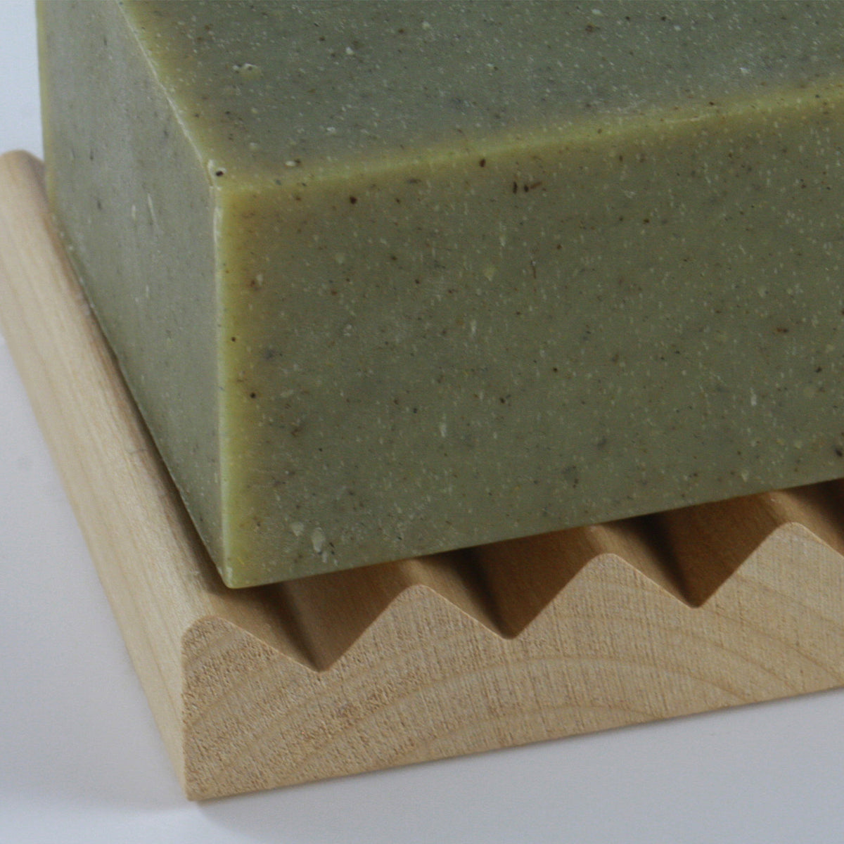 Close-up of Wooden Soap Rest with raised grooves for water drainage and soap placement photographed up close and on neutral background
