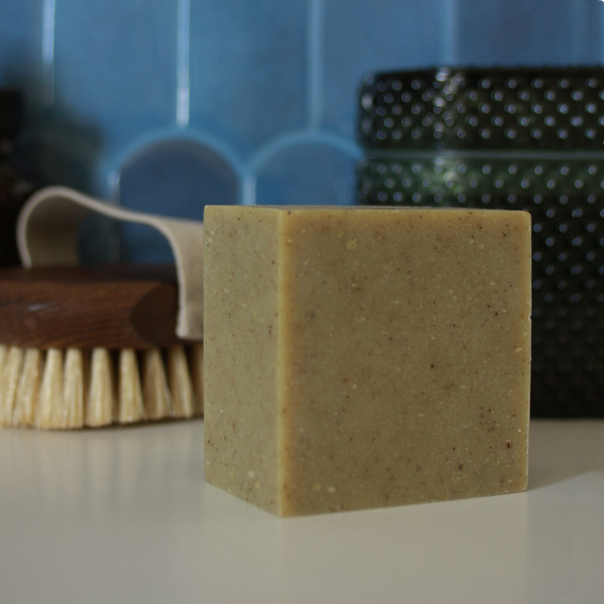 green speckled soap against blue tile stylized background