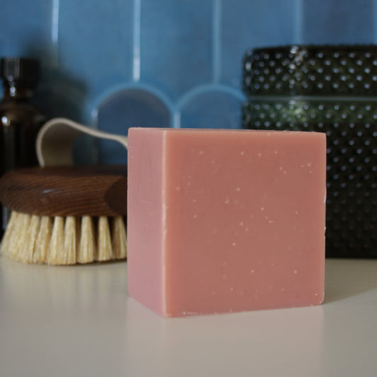 block of pink soap against blue stylized tile backdrop