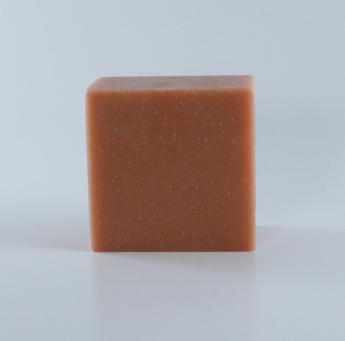 Resistance Rose Geranium + Sandalwood Soap with an orange pink finish and clean rectangular shape photographed from the front on a neutral background.