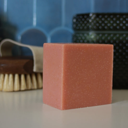 peach block of soap against blue stylized backdrop