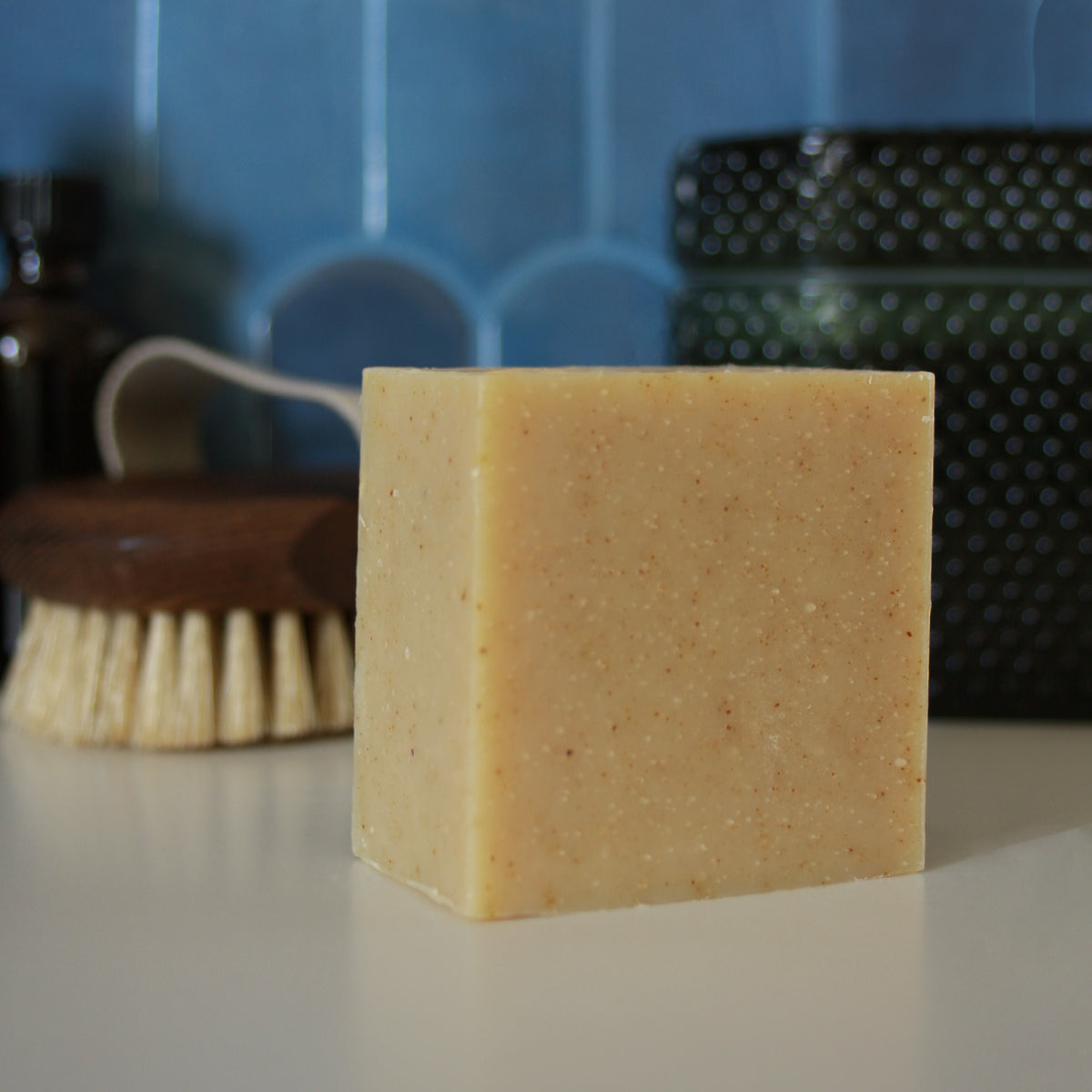 yellow speckled square soap against stylized blue tile background