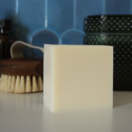 creamy white block of soap against stylized blue tile background